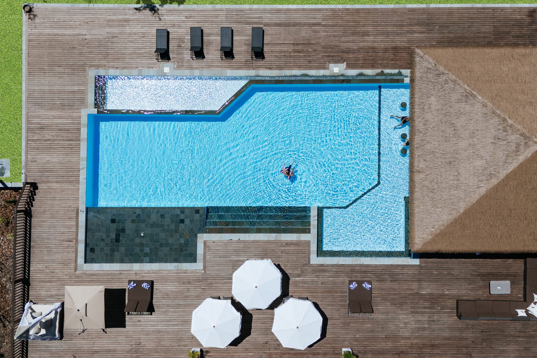 Aerial view of the resort's shared swimming pool at Tanah Mympi, with guests relaxing in the water