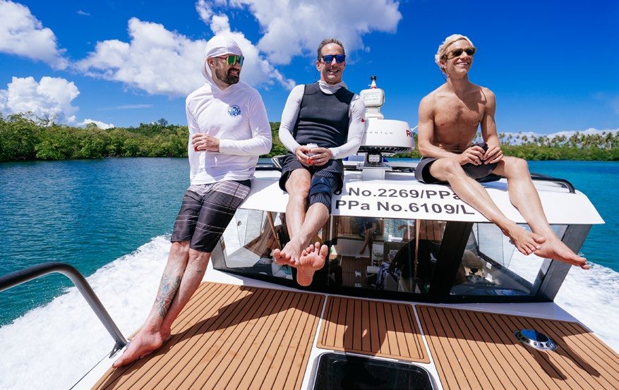 Three surfers relaxing aboard the sole-use TM 36 foot speedboat