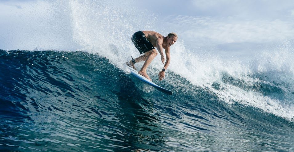 A surfer riding a wave at one of the local breaks reached by speedboat